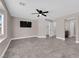 A spacious bedroom with tiled floors, neutral walls, ceiling fan, and mounted television at 720 Picasso Picture Ct, North Las Vegas, NV 89081