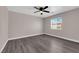Well lit bedroom with wood-look flooring, ceiling fan, and a bright window at 720 Picasso Picture Ct, North Las Vegas, NV 89081