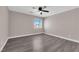 An airy bedroom with wood-look flooring, neutral walls, ceiling fan, and a window providing ample natural light at 720 Picasso Picture Ct, North Las Vegas, NV 89081