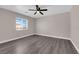 Neutral toned bedroom offers wood-look flooring, ceiling fan and bright window at 720 Picasso Picture Ct, North Las Vegas, NV 89081