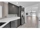 Kitchen with dark cabinets, stainless steel fridge, tile floors that extend into the living room at 720 Picasso Picture Ct, North Las Vegas, NV 89081
