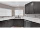 Modern kitchen features dark cabinets, stainless steel appliances, quartz countertops and a black sink at 720 Picasso Picture Ct, North Las Vegas, NV 89081