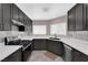 Modern kitchen featuring dark cabinetry, white countertops, stainless steel appliances, and stylish backsplash detailing at 720 Picasso Picture Ct, North Las Vegas, NV 89081