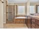 Well-appointed bathroom with glass-enclosed shower, soaking tub, and tile accents at 7505 Java Sparrow St, North Las Vegas, NV 89084