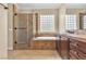 Bathroom featuring glass enclosed shower and luxurious soaking tub at 7505 Java Sparrow St, North Las Vegas, NV 89084