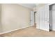 A beige bedroom with carpeted floors and a closet with doors at 7505 Java Sparrow St, North Las Vegas, NV 89084