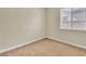Clean and simple bedroom featuring neutral walls, neutral carpet, and a bright window at 7505 Java Sparrow St, North Las Vegas, NV 89084