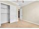 A beige bedroom with a ceiling fan, carpeted floors, a closet, and doors at 7505 Java Sparrow St, North Las Vegas, NV 89084