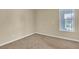 Cozy bedroom featuring neutral carpeting, a window view, and natural light at 7505 Java Sparrow St, North Las Vegas, NV 89084