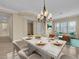 A dining table with beige chairs is staged in the formal dining room, with ample seating and natural light at 7505 Java Sparrow St, North Las Vegas, NV 89084