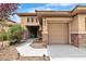 The exterior of the home features stone accents, a well-maintained lawn, and a covered front porch at 7505 Java Sparrow St, North Las Vegas, NV 89084