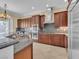 Kitchen with wood cabinets, granite countertops, stainless steel appliances and a view to the outside at 7505 Java Sparrow St, North Las Vegas, NV 89084