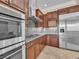 Kitchen showcasing wood cabinetry, stainless steel double oven and refrigerator, and granite countertops at 7505 Java Sparrow St, North Las Vegas, NV 89084