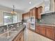 Kitchen with wood cabinets, granite countertops, stainless steel appliances and view to the backyard at 7505 Java Sparrow St, North Las Vegas, NV 89084