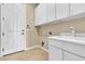 Bright laundry room has built-in cabinets, sink and modern appliances at 7505 Java Sparrow St, North Las Vegas, NV 89084