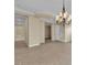 Open-concept living area features neutral walls and tiled flooring with an elegant chandelier at 7505 Java Sparrow St, North Las Vegas, NV 89084