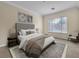Bedroom with neutral walls, carpet and a large window overlooking the greenery of the yard at 7505 Java Sparrow St, North Las Vegas, NV 89084