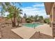 An attractive pool area featuring a pool, spa, trees, and a wall at 7505 Java Sparrow St, North Las Vegas, NV 89084