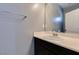 Simple, clean bathroom with dark cabinets, white countertop, and large mirror at 7609 Aubusson Ct, Las Vegas, NV 89149
