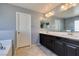 A bathroom boasts a double vanity, a large mirror, and tile flooring at 7609 Aubusson Ct, Las Vegas, NV 89149