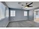 This bedroom features carpet, natural light from two windows, and a ceiling fan at 7609 Aubusson Ct, Las Vegas, NV 89149