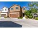 Two-story tan home featuring a two-car garage, neutral landscaping and a tile roof at 7609 Aubusson Ct, Las Vegas, NV 89149