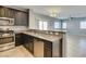 Open concept kitchen with stainless appliances, granite counters, and view to the living space at 7609 Aubusson Ct, Las Vegas, NV 89149
