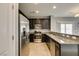 Stylish kitchen with stainless steel appliances and a granite breakfast bar overlooking the living area at 7609 Aubusson Ct, Las Vegas, NV 89149