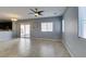 Open concept living room with tile floors, neutral gray paint, a ceiling fan and view of the kitchen at 7609 Aubusson Ct, Las Vegas, NV 89149
