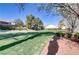 Lush backyard featuring well-maintained lawn, mature trees, and manicured landscaping at 7669 Fieldfare Dr, North Las Vegas, NV 89084
