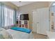 Bright bedroom featuring a comfortable bed, natural light, and shelving with television at 7669 Fieldfare Dr, North Las Vegas, NV 89084