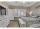 Well-lit bedroom showcases a television, white furniture, and a comfortable bed with soft linens at 7669 Fieldfare Dr, North Las Vegas, NV 89084