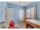 A blue bedroom furnished with a custom built-in wooden desk and sofa at 7669 Fieldfare Dr, North Las Vegas, NV 89084