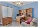 A blue bedroom furnished with a custom built-in wooden desk, drawers and shelves at 7669 Fieldfare Dr, North Las Vegas, NV 89084