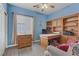 A blue bedroom furnished with a custom built-in wooden desk, drawers and shelves at 7669 Fieldfare Dr, North Las Vegas, NV 89084