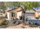 Inviting single-story home with desert landscaping, mature trees, and a two-car garage at 7669 Fieldfare Dr, North Las Vegas, NV 89084