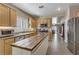 Spacious kitchen with a wood-topped island, light wood cabinets, and stainless steel appliances at 7669 Fieldfare Dr, North Las Vegas, NV 89084