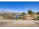 Picturesque lake view showcasing serene water, natural landscaping, and distant mountain scenery at 7669 Fieldfare Dr, North Las Vegas, NV 89084