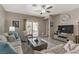 Inviting living room with lots of light, comfortable seating, ceiling fan and a wall-mounted television at 7669 Fieldfare Dr, North Las Vegas, NV 89084