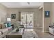 Bright living room featuring stylish furniture, neutral tones and a sliding door leading to a patio at 7669 Fieldfare Dr, North Las Vegas, NV 89084