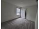 This bedroom features neutral carpeting, a window, and a standard closet at 7672 Lush Oasis Ave, Las Vegas, NV 89113