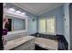 Relaxing bathroom featuring a soaking tub, neutral tones, and a window for natural light at 7728 Whispering River St, Las Vegas, NV 89131
