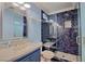 Bathroom featuring a walk-in shower with blue tile surround, a modern vanity, and a neutral color palette at 7728 Whispering River St, Las Vegas, NV 89131