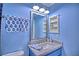 Stylish bathroom featuring a marble countertop and a blue vanity with a towel rack at 7728 Whispering River St, Las Vegas, NV 89131