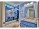 Modern bathroom featuring blue tiling in shower, wood floors, and a vanity at 7728 Whispering River St, Las Vegas, NV 89131