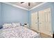 Bright bedroom with two doors, a bed with floral bedding, and natural light at 7728 Whispering River St, Las Vegas, NV 89131