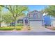 Charming two-story home with blue siding, red shutters, landscaped yard and a two car garage at 7728 Whispering River St, Las Vegas, NV 89131