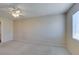 This bedroom boasts an overhead fan, a light-colored carpet, and a single window at 7732 Almeria Ave, Las Vegas, NV 89128