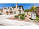 Exterior view of the townhome, featuring a two-car garage and desert-style landscaping at 7732 Almeria Ave, Las Vegas, NV 89128