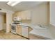Practical kitchen with white appliances, neutral countertops, and tile flooring at 7732 Almeria Ave, Las Vegas, NV 89128